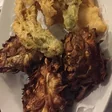 A white plate of crisp golden fried artichokes